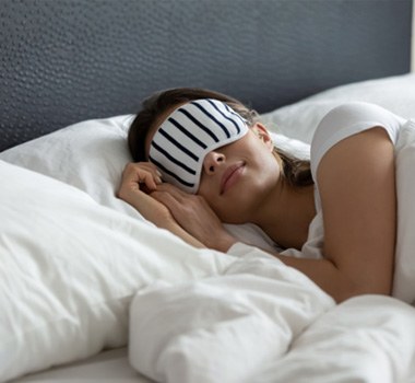 Woman wearing eye mask, sleeping peacefully