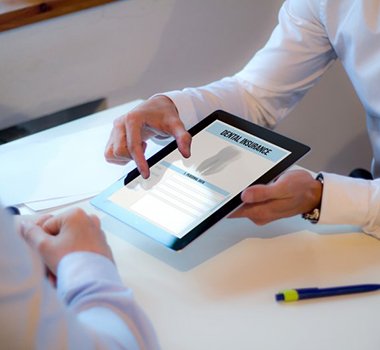 a person showing a tablet for dental insurance