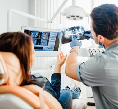  a dentist showing a patient their X-rays