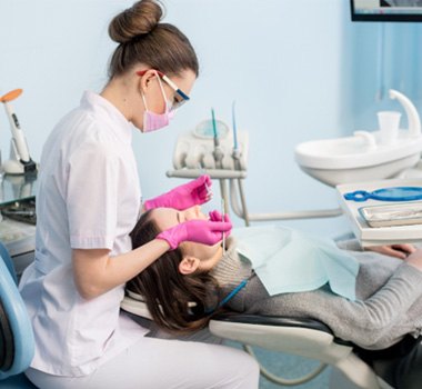  a dental hygienist cleaning a patient’s teeth