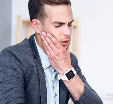 Man holding jaw in pain