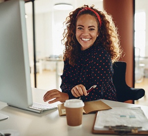 Business woman smiling while working on computer