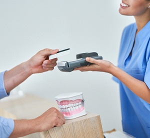 Patient paying for the cost of cosmetic dentistry in Landrum