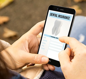 Patient in Landrum reviewing dental insurance paperwork for crown treatment