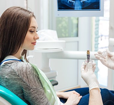 dentist showing a dental implant to a patient