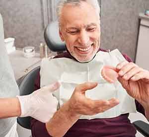 Patient in Landrum smiling at dentist after getting dentures