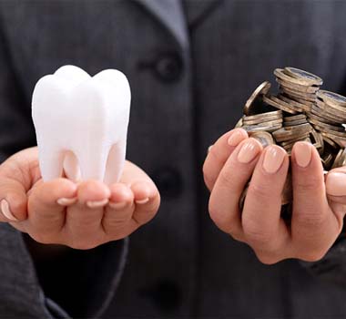 Hand holding tooth and coins