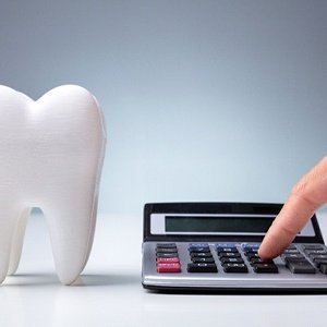 Model tooth and calculator representing the cost of emergency dental care in Landrum