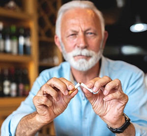 older man breaking a cigarette
