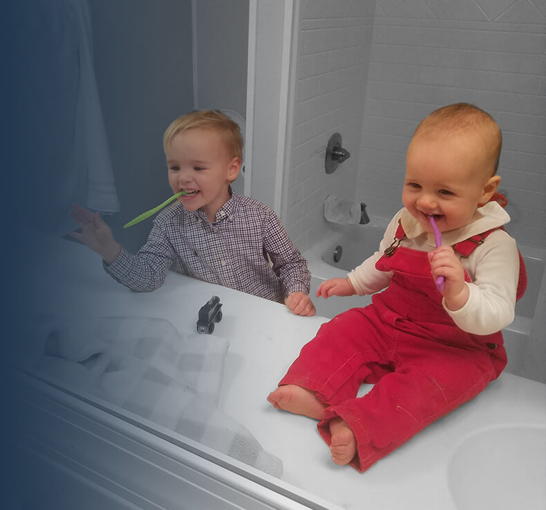 children brushing their teeth in mirror