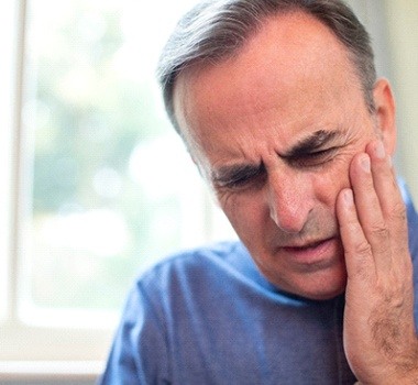 man holding jaw in pain