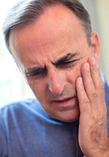 man holding jaw in pain