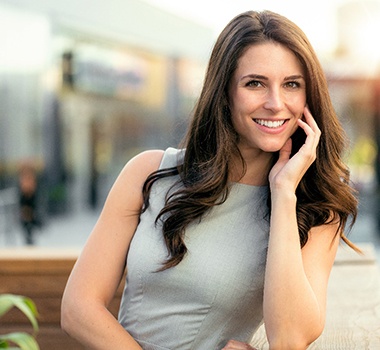 Woman outside on porch leaning and smiling