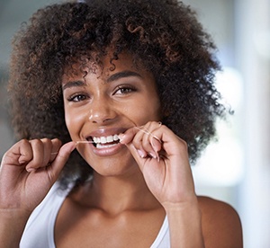 woman smiling while flossing 
