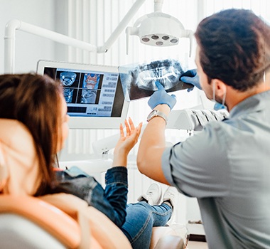 Patient and a dentist looking at an x-ray