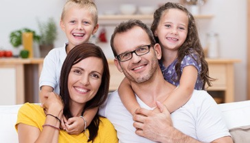 Mother father and two children smiling