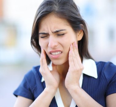 Woman with jaw pain, suffering symptoms of TMD
