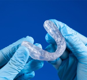 Gloved hands holding occlusal splint 