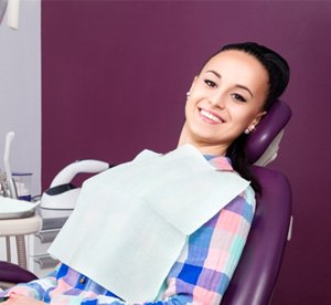 Smiling dental patient reclining in treatment chair 