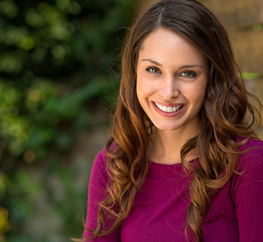 A woman smiling outside.