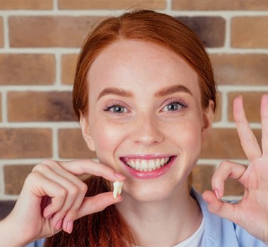 Teen holding extracted wisdom tooth in Landrum 