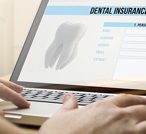 Filling out dental insurance form on a laptop