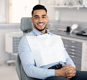 Man sitting down in dental chair and smiling