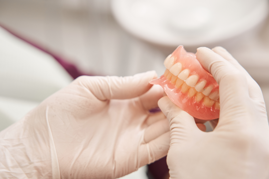 Dentist holding dentures
